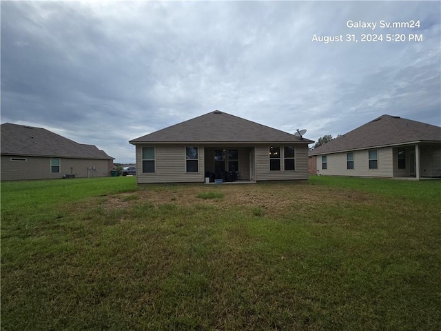 rear view of house featuring a yard