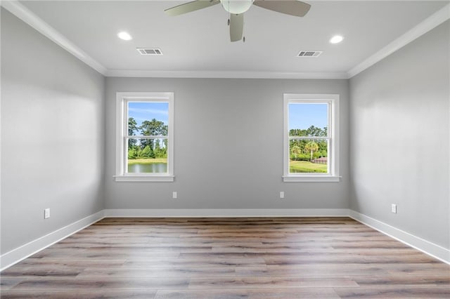 empty room with ceiling fan, a wealth of natural light, and crown molding