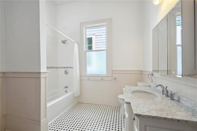 full bathroom with tiled shower / bath combo, vanity, toilet, and a wealth of natural light