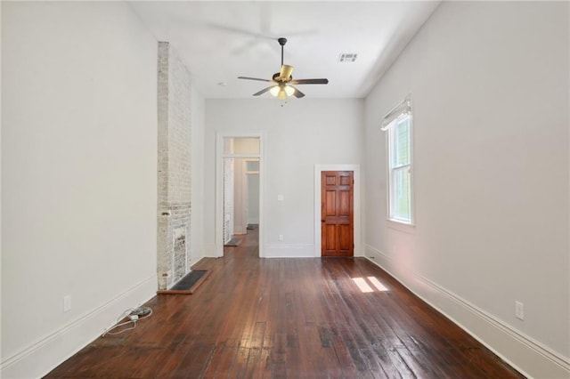 interior space with ceiling fan, a fireplace, and dark hardwood / wood-style flooring