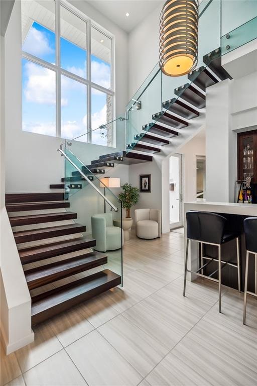 staircase featuring a high ceiling and tile patterned flooring