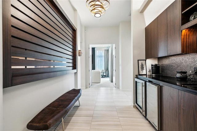 interior space with tasteful backsplash, wine cooler, light tile patterned flooring, and dark brown cabinetry