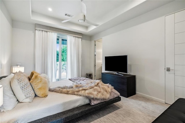 bedroom featuring ceiling fan and a tray ceiling