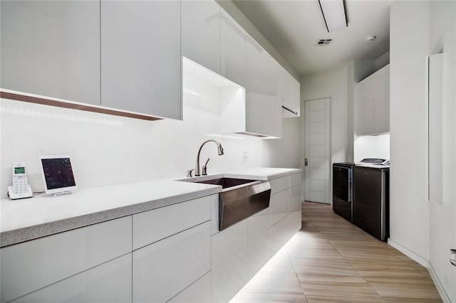 kitchen featuring electric range, light tile patterned floors, sink, and white cabinets