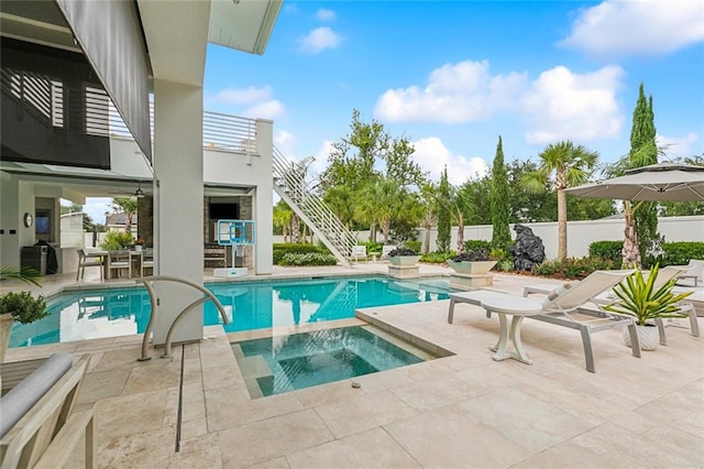 view of swimming pool featuring an in ground hot tub and a patio area