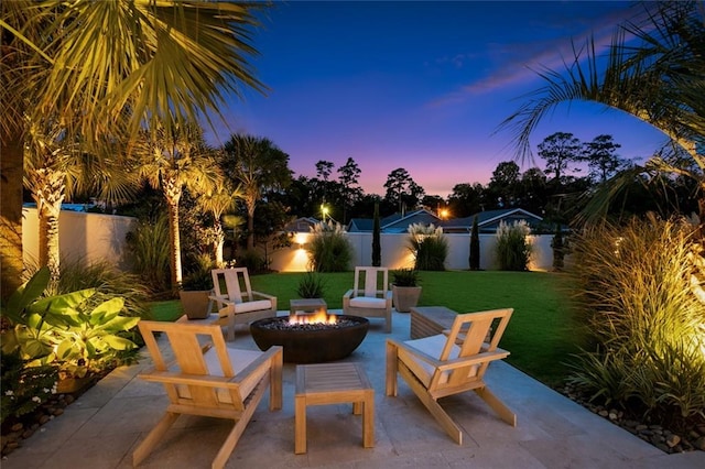 patio terrace at dusk with a lawn and a fire pit