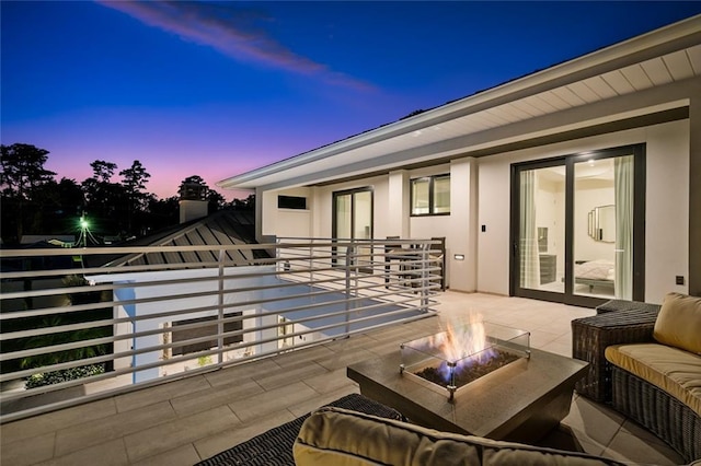 patio terrace at dusk featuring a fire pit