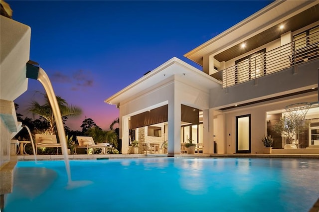 pool at dusk with pool water feature