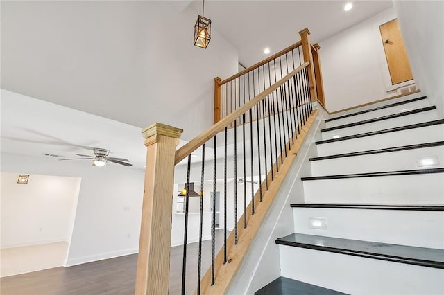 stairway with ceiling fan and hardwood / wood-style flooring