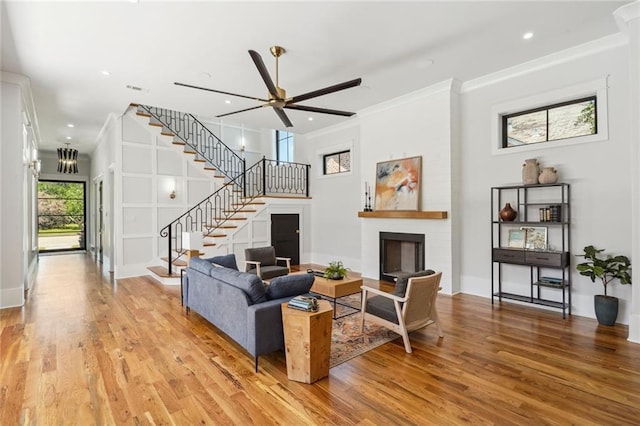 living room featuring plenty of natural light, ceiling fan, a brick fireplace, and light hardwood / wood-style floors