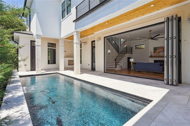 view of swimming pool featuring ceiling fan and a patio area