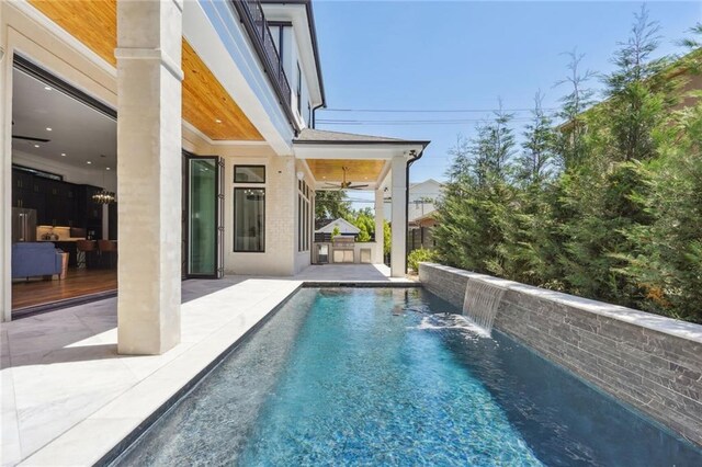 view of pool featuring pool water feature, ceiling fan, and a patio