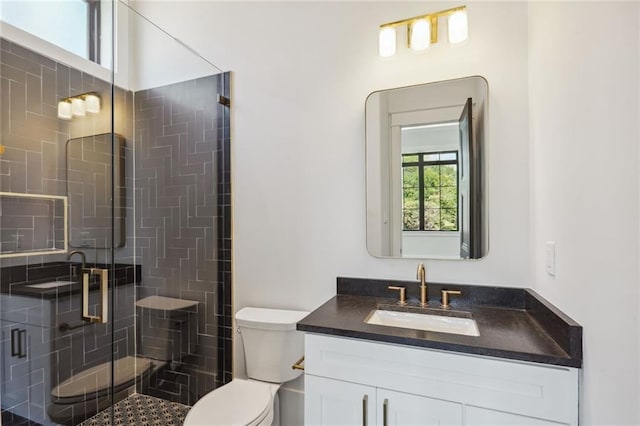 bathroom with a shower with shower door, toilet, and vanity