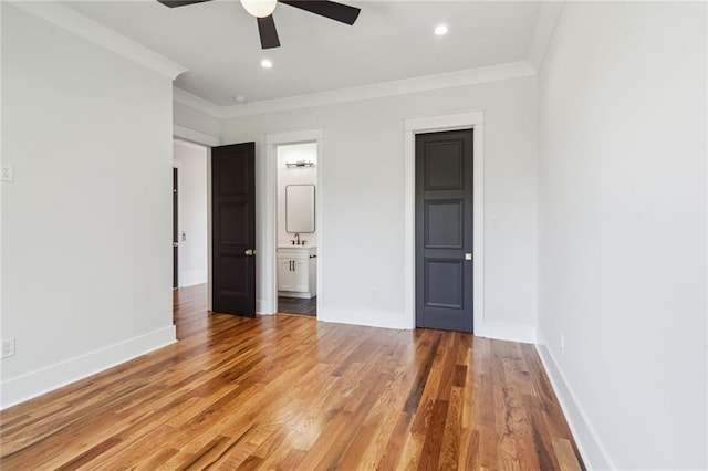 unfurnished bedroom featuring ceiling fan, hardwood / wood-style flooring, ornamental molding, and ensuite bath