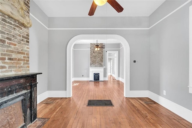 interior space with ceiling fan, hardwood / wood-style flooring, and a fireplace