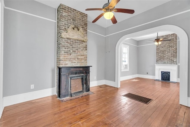 unfurnished living room with a fireplace, hardwood / wood-style floors, and ceiling fan