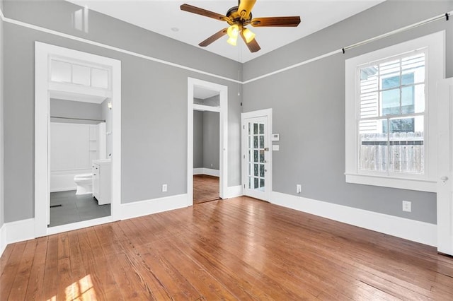 unfurnished bedroom with ceiling fan, hardwood / wood-style flooring, and ensuite bath