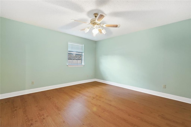 unfurnished room featuring ceiling fan, a textured ceiling, baseboards, and wood finished floors