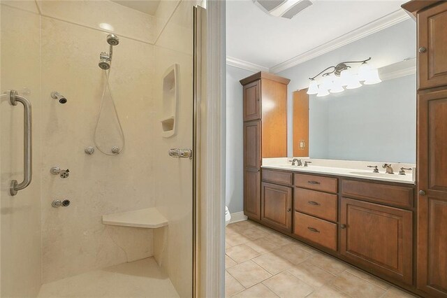 bathroom featuring vanity, ornamental molding, tile patterned floors, and a tile shower