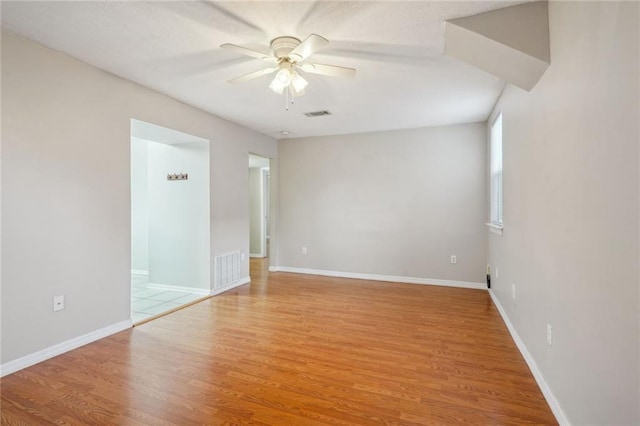 spare room featuring ceiling fan and light hardwood / wood-style flooring