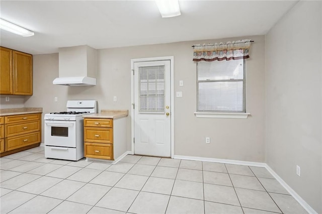 kitchen with light tile patterned flooring, white range with gas stovetop, and custom range hood