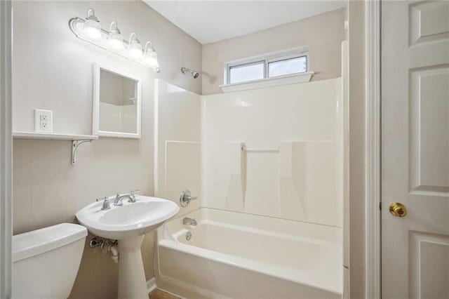 bathroom featuring tub / shower combination and toilet