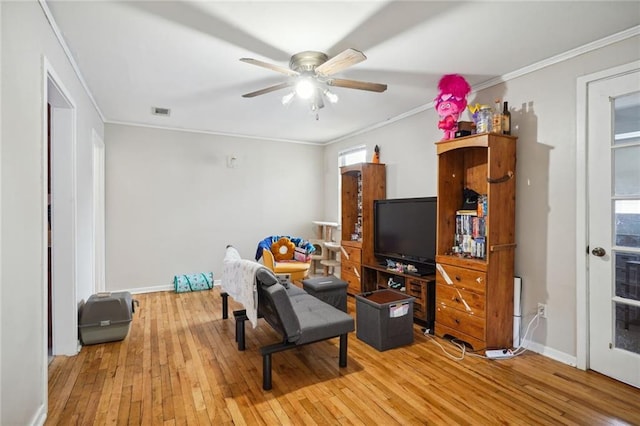 living area featuring crown molding, light hardwood / wood-style floors, and ceiling fan