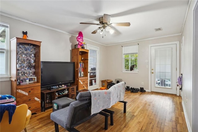 living room featuring ceiling fan, light hardwood / wood-style flooring, crown molding, and a healthy amount of sunlight