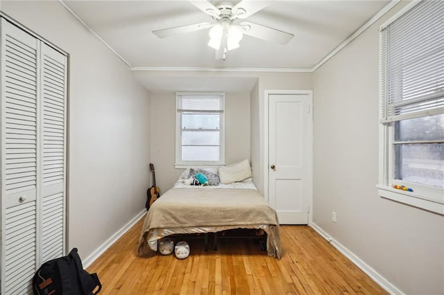 bedroom with crown molding, light hardwood / wood-style floors, and ceiling fan