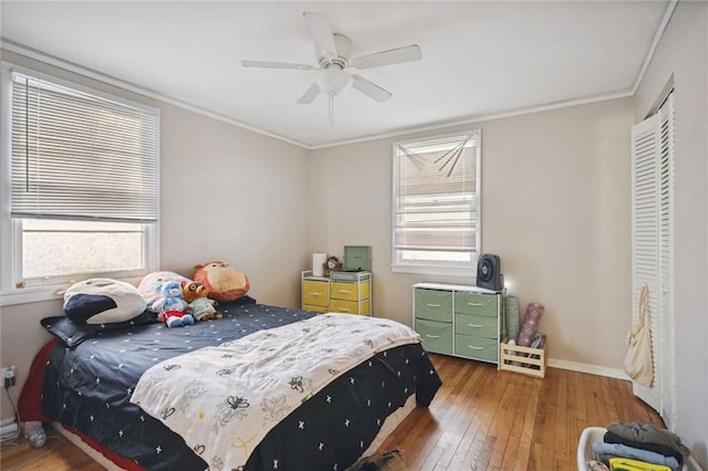 bedroom featuring ceiling fan, hardwood / wood-style flooring, a closet, and ornamental molding