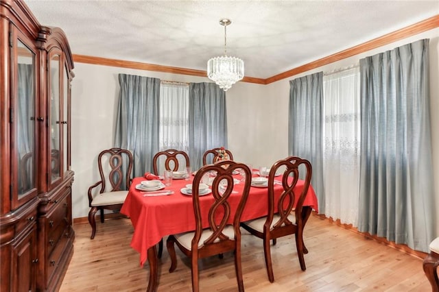 dining area featuring ornamental molding, light hardwood / wood-style flooring, and a chandelier