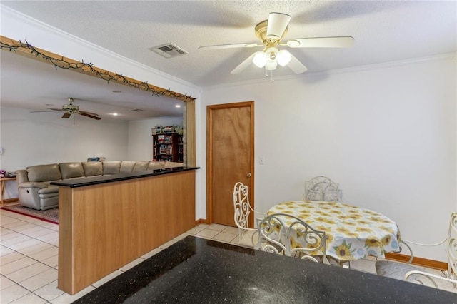 kitchen featuring ceiling fan, light tile patterned floors, and crown molding