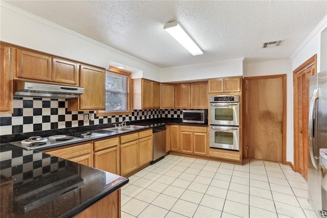 kitchen with ornamental molding, backsplash, light tile patterned floors, stainless steel appliances, and sink