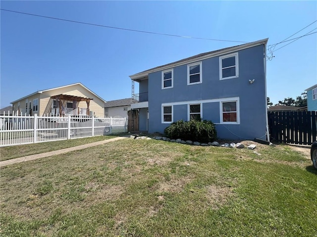 rear view of property featuring a lawn