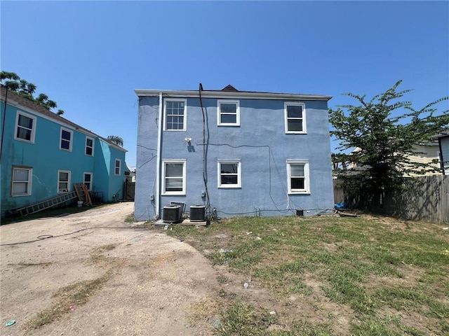 rear view of house with a lawn and central air condition unit