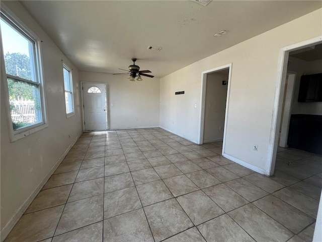 tiled spare room featuring ceiling fan