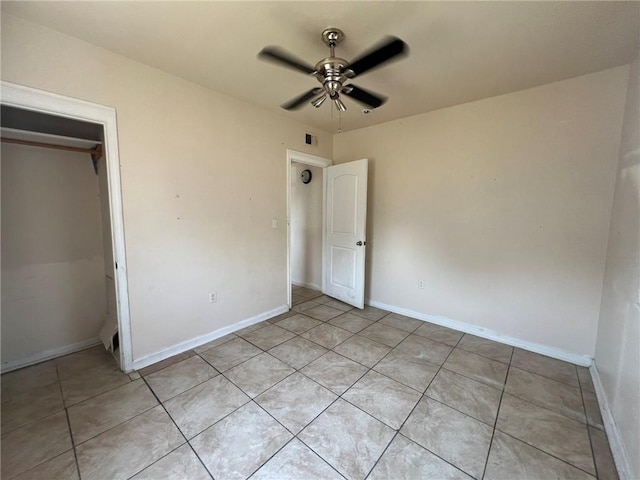 unfurnished bedroom with light tile patterned floors, ceiling fan, and a closet