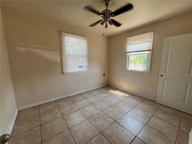 tiled spare room featuring ceiling fan