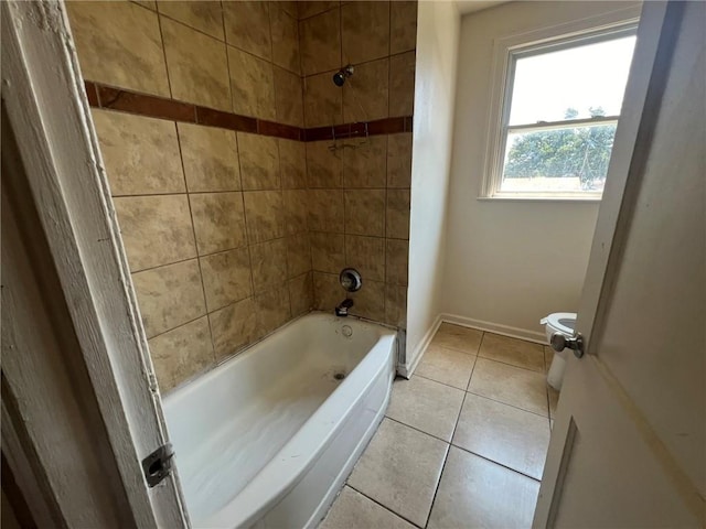 bathroom with toilet, tiled shower / bath combo, and tile patterned floors