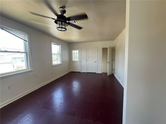 spare room with dark wood-type flooring and ceiling fan