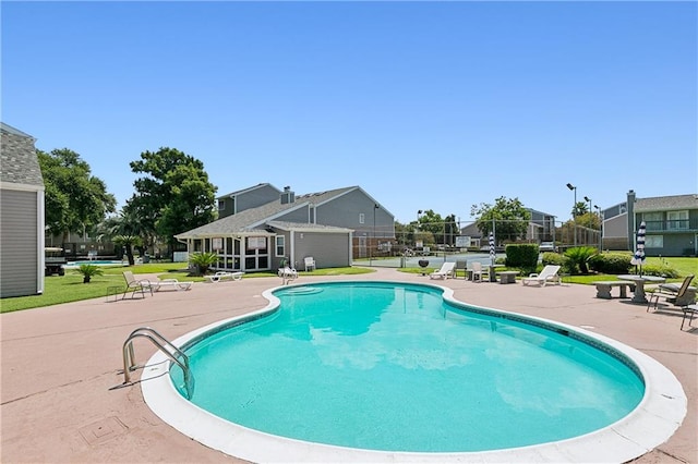 view of swimming pool featuring a yard and a patio