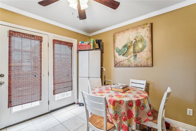 tiled dining space featuring ornamental molding and ceiling fan