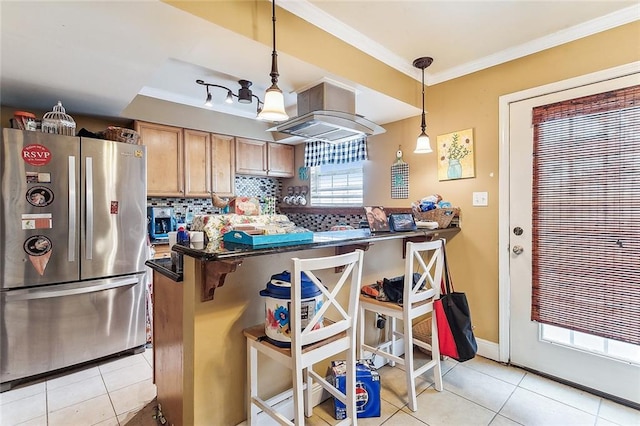 kitchen featuring stainless steel fridge, pendant lighting, a kitchen bar, crown molding, and island range hood