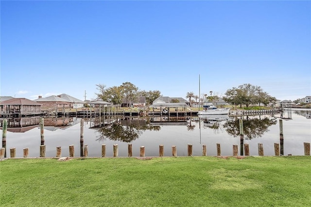 view of dock with a yard and a water view