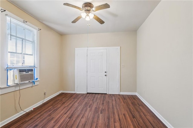 empty room featuring cooling unit, baseboards, a ceiling fan, and wood finished floors