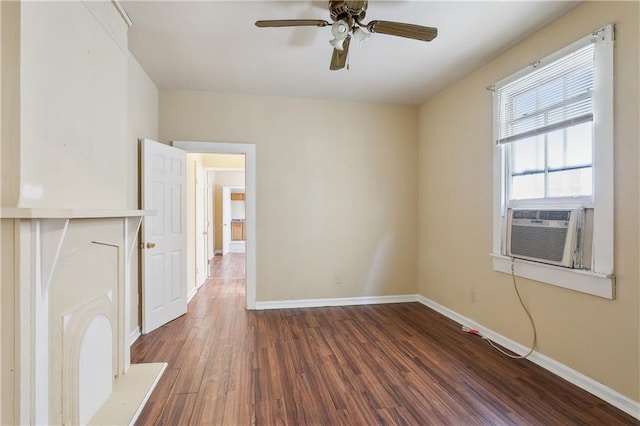 empty room featuring cooling unit, ceiling fan, baseboards, and wood finished floors