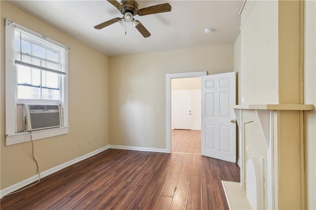 spare room featuring dark wood-style flooring, baseboards, a ceiling fan, and cooling unit