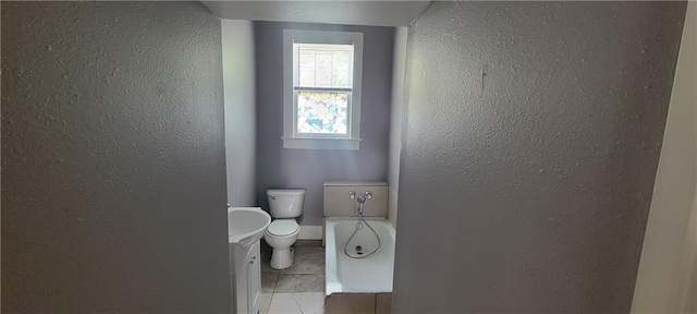 bathroom featuring vanity, toilet, a bathing tub, and tile patterned flooring