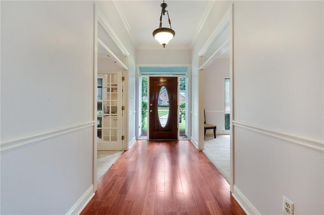 foyer featuring wood-type flooring and ornamental molding