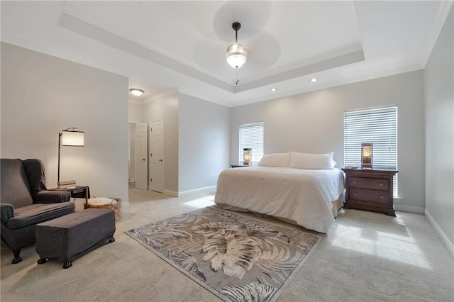 carpeted bedroom featuring crown molding and a tray ceiling